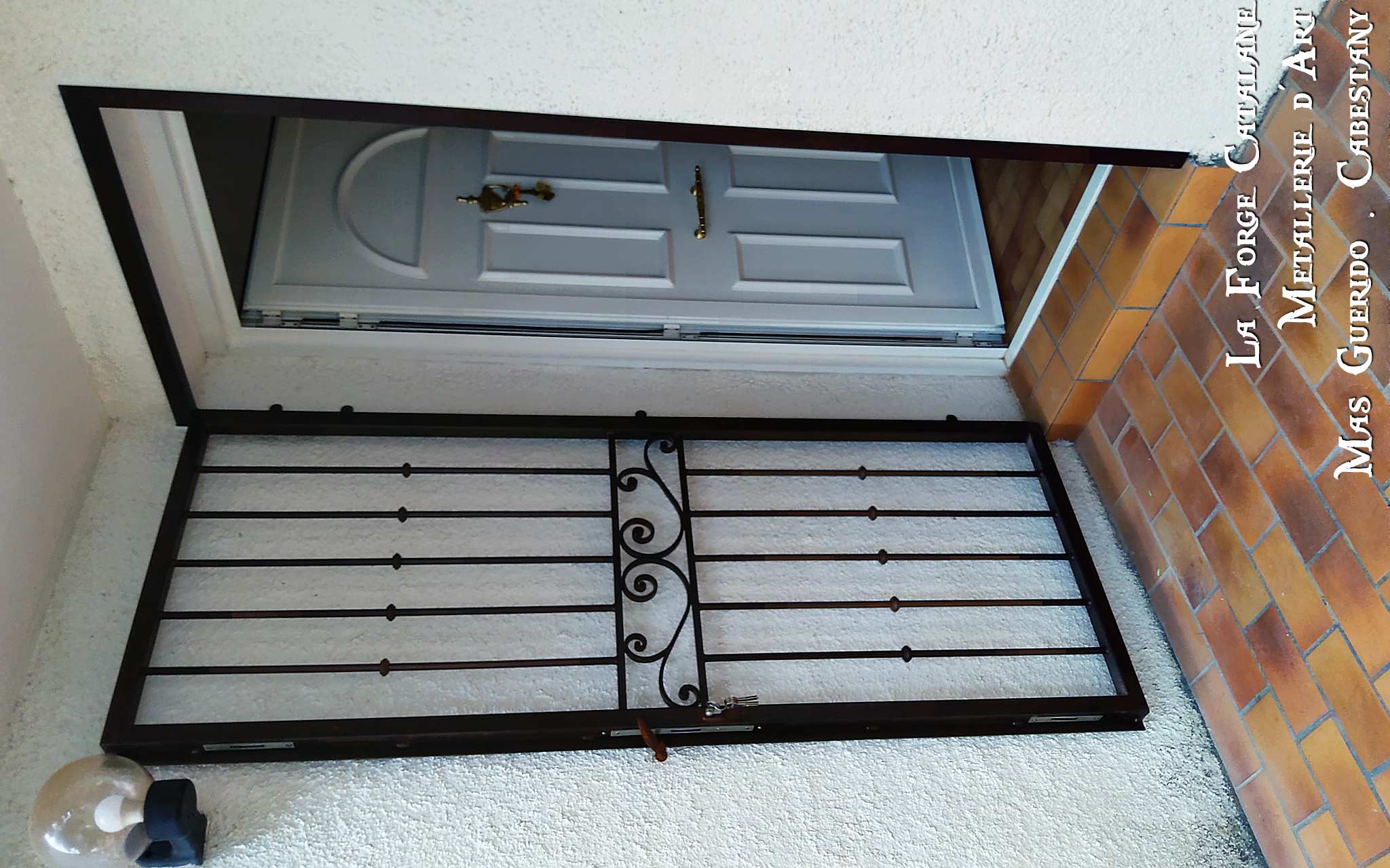 grille articulee devant porte rouille barreaux fer rond bagues frise volute la forge catalane 2.jpg